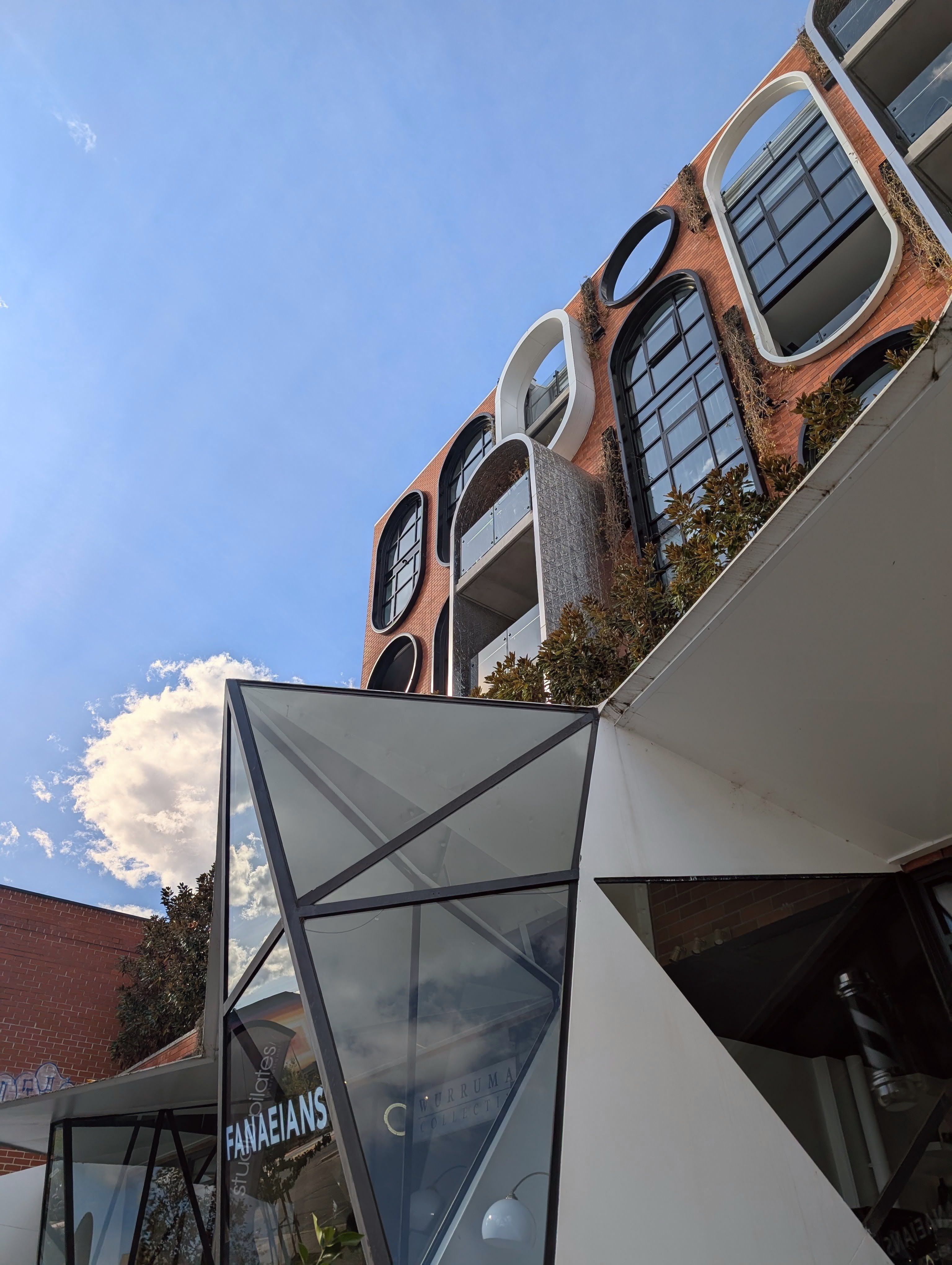 Modern glass facade reflecting the surrounding streetscape